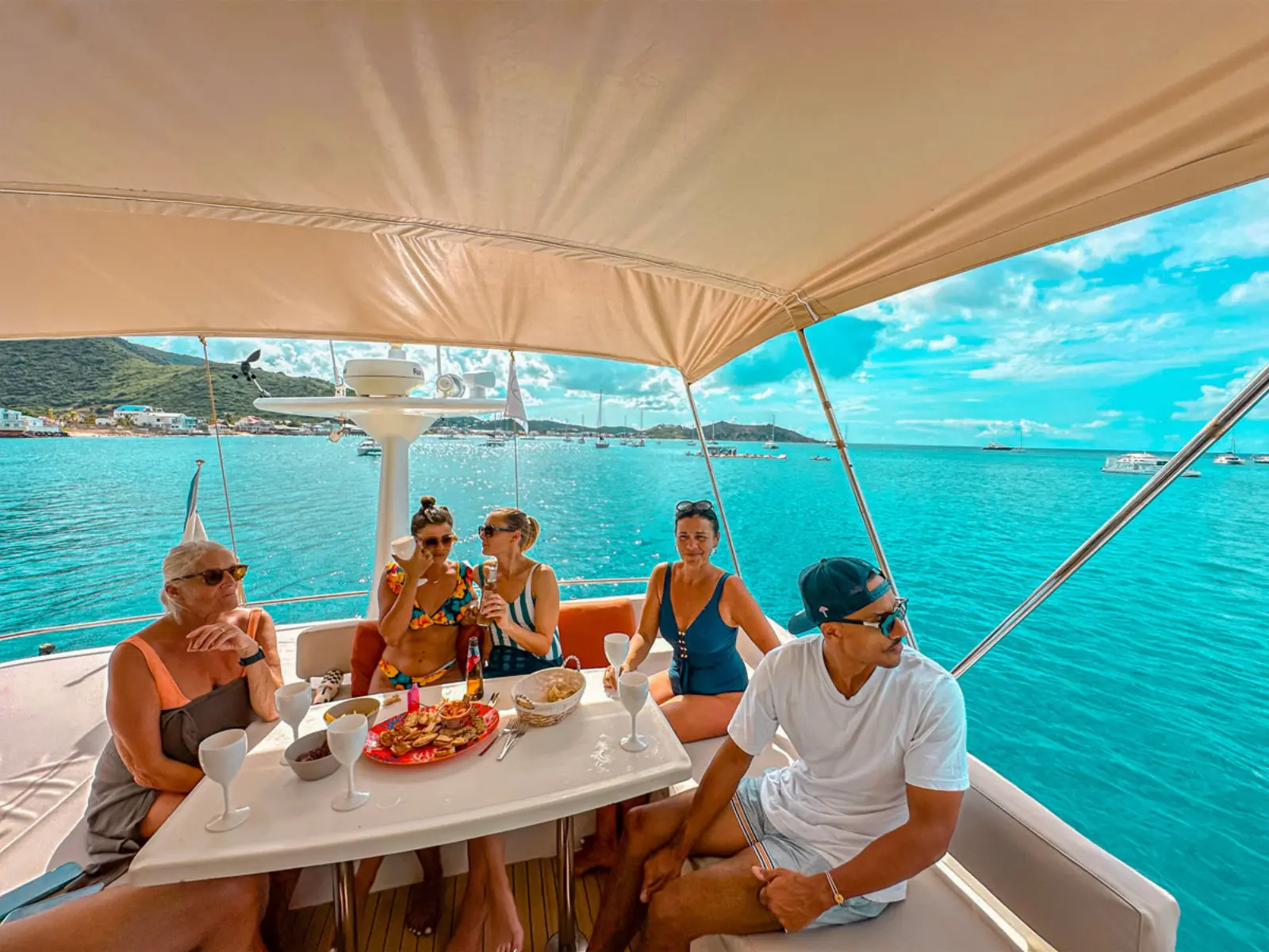 Group enjoying lunch and drinks on private boat charter in St Martin with ocean views