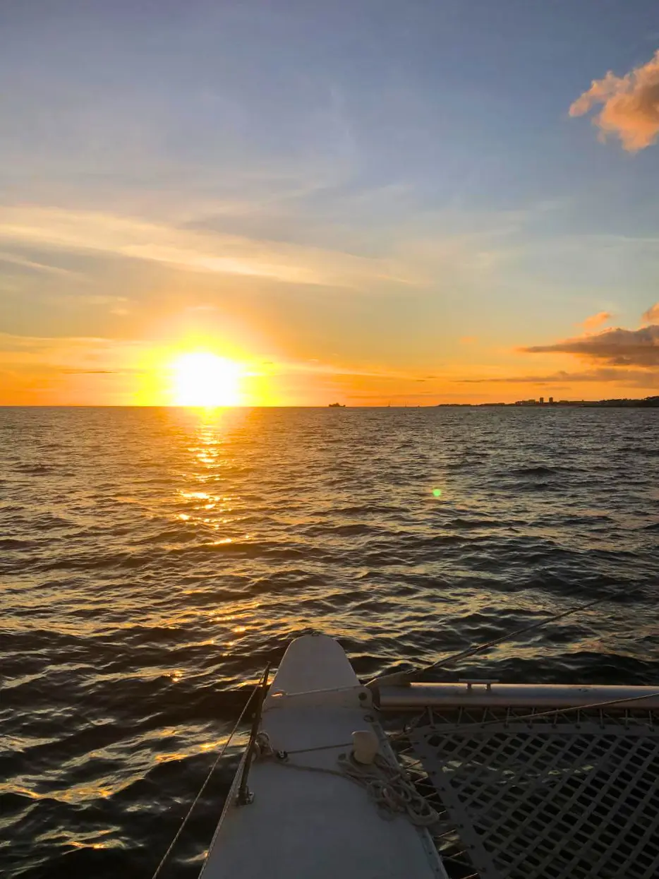 Open Caribbean sunset viewed from the bow of a private catamaran